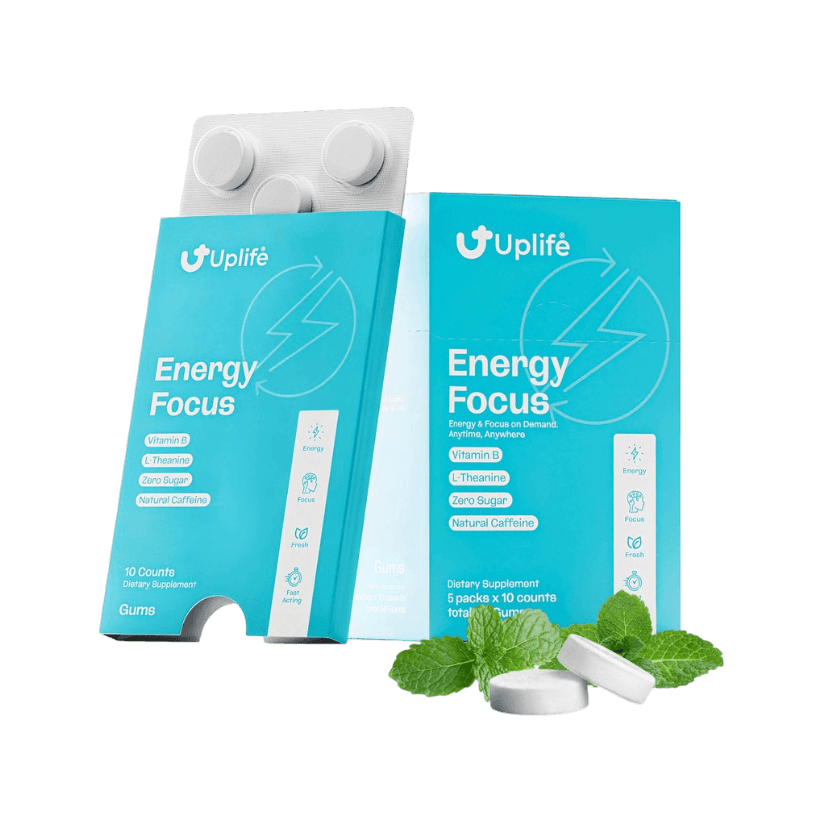 Two turquoise and white Uplife Energy Focus gummy boxes shown on a black background, with a blister pack of gummies behind them and mint leaves and two white gummies in front.